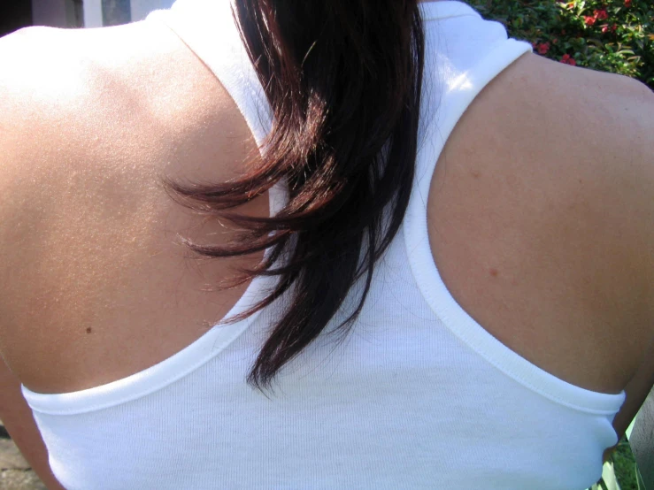 the back of a woman wearing a white tank top