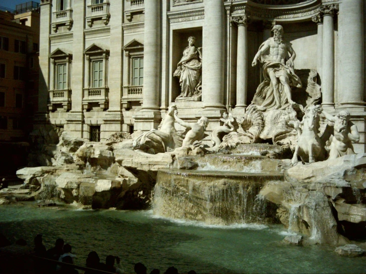 a fancy fountain with statues in front of a large building
