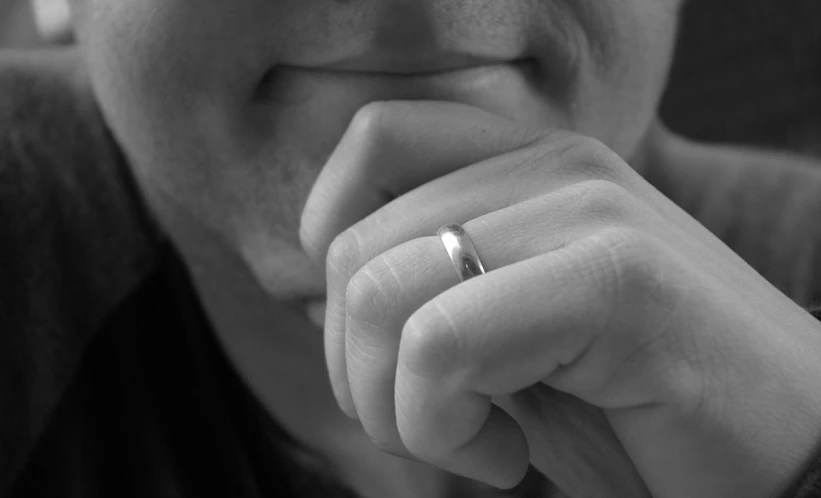 black and white pograph of a person holding a ring