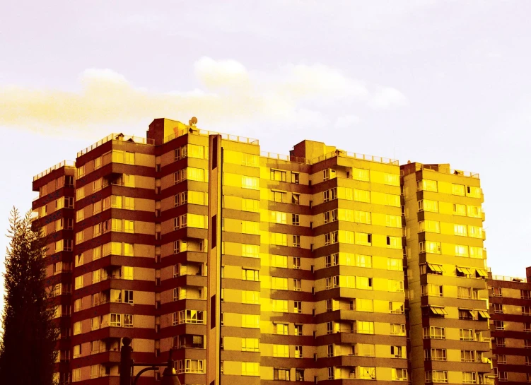 a tall yellow brick building towering over other buildings