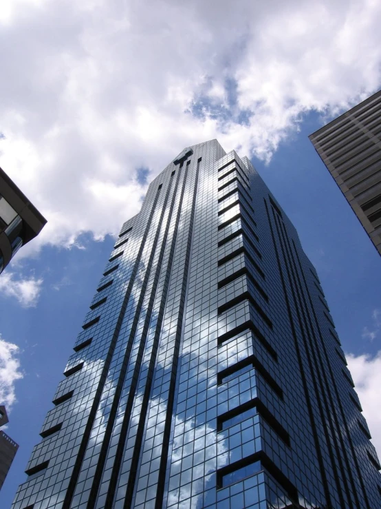 looking up at the sky, some tall buildings and the clouds in the distance