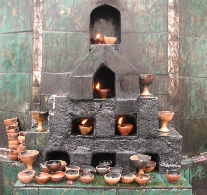 many different pots sitting in a small stone structure