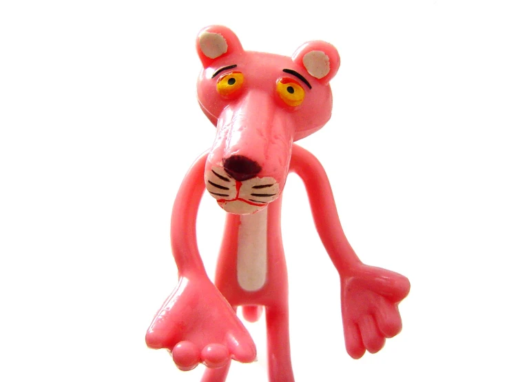 pink toy with eyes and tail sitting in front of white background