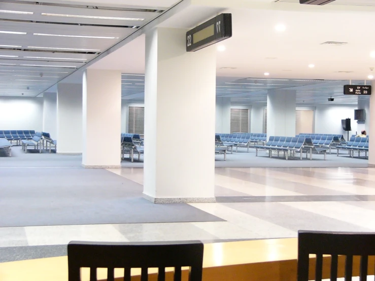 the room has several tables and chairs arranged around the clock