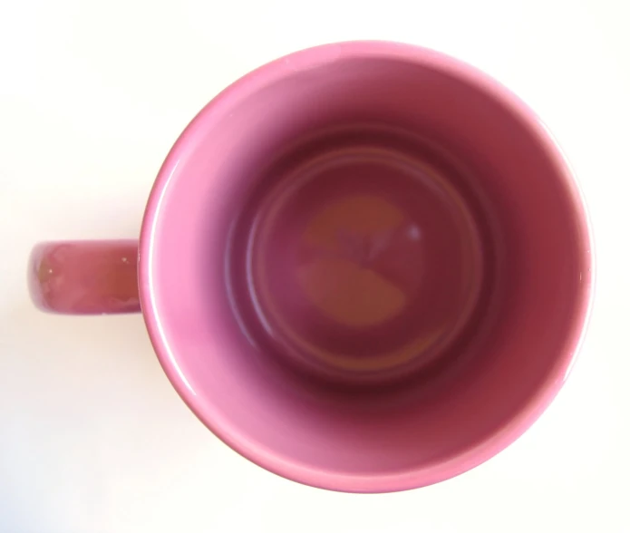 a pink coffee cup on a white surface