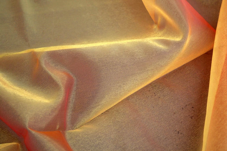 a yellow, red and gold piece of cloth on a bed