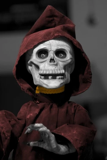 a skeleton dressed in a red cape