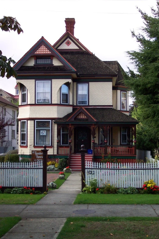 a white and brown house with a gate in front of it