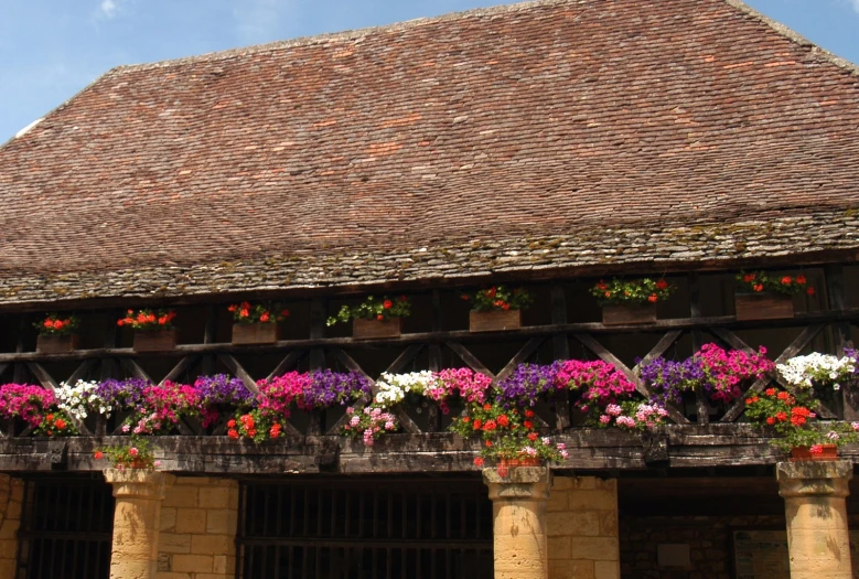 a large brick building with lots of flowers growing on it