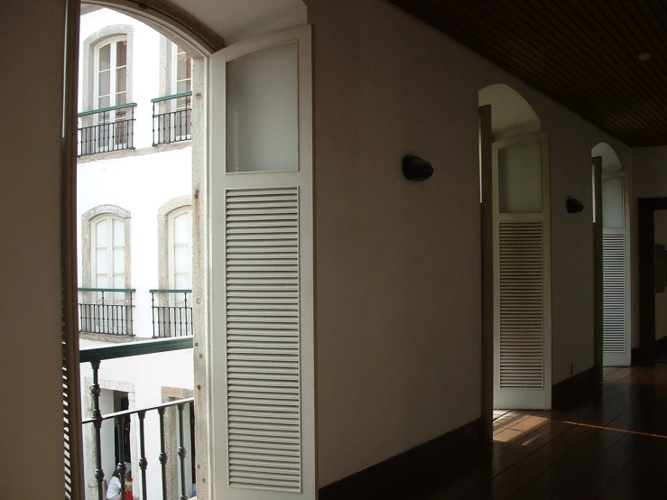 an archway into a small room with a balcony and door