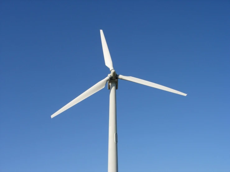 a wind turbine on top of a field in a sunny day