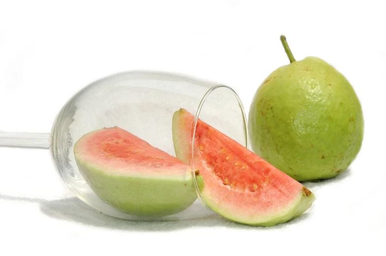 two pieces of watermelon in glass sitting next to a green apple