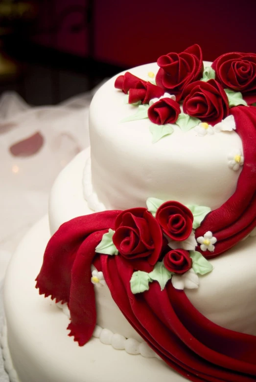 the two - tiered cake has red and white decorations on it