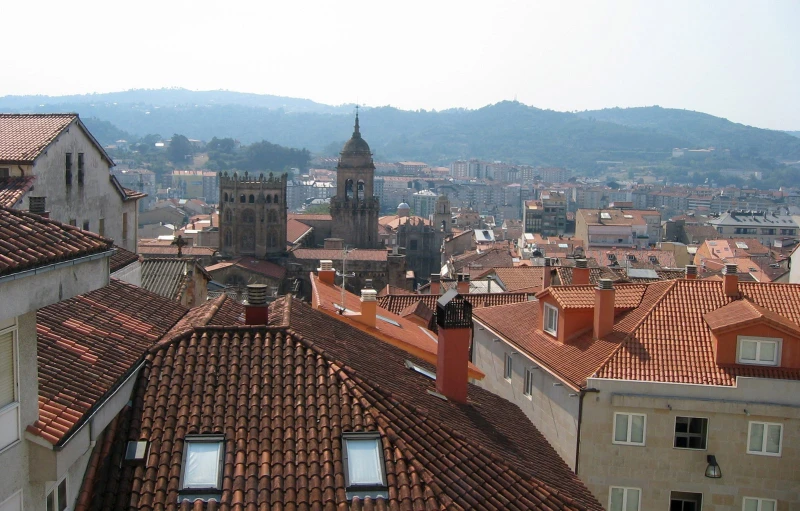 there is a clock tower in the distance as many buildings stand on the other side of the building