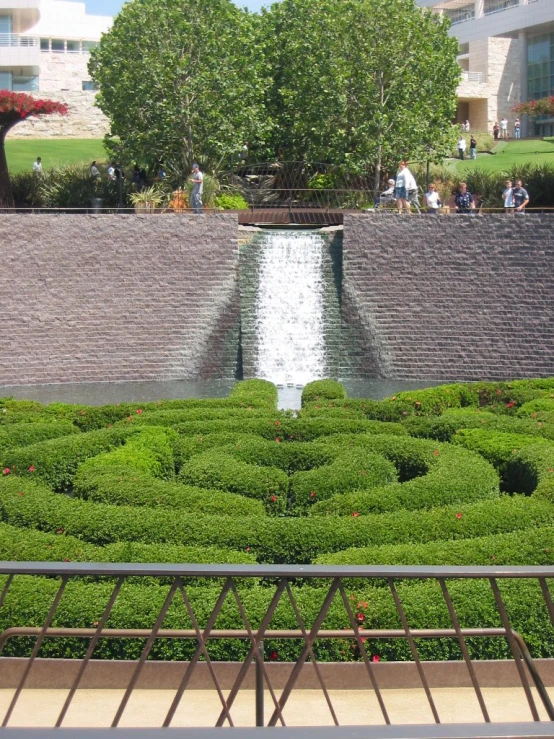 the large garden features many hedges, trees and a waterfall