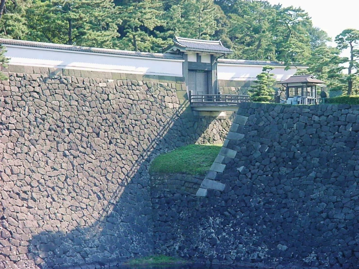 a man is standing at the top of a hill on a very small body of water