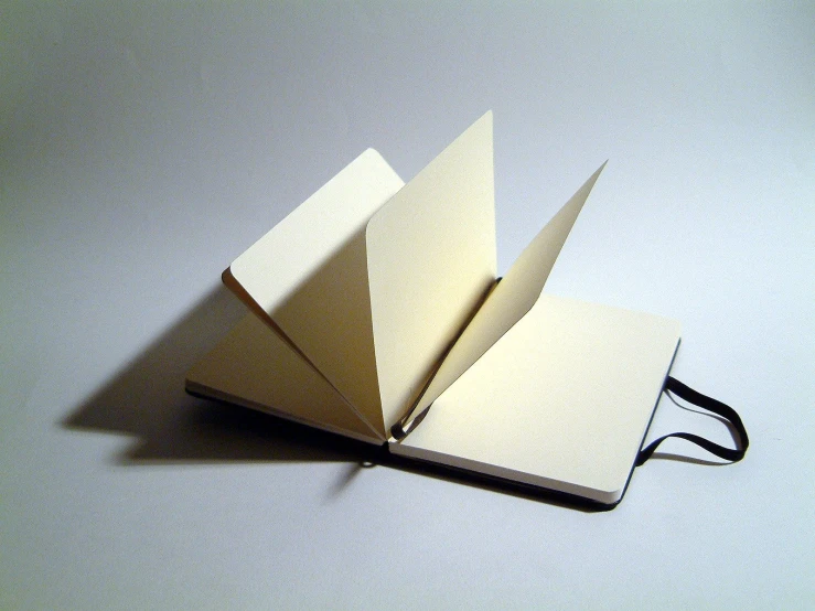 an open book on white paper sitting on top of a table