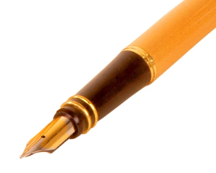 an orange fountain pen with gold trim and tip