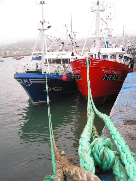 two fishing vessels tied up near dock in water