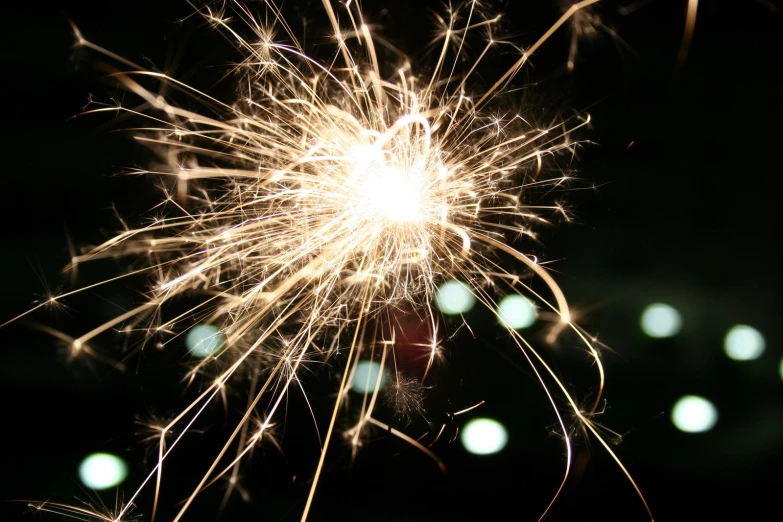 a fireworks is lit against a dark background