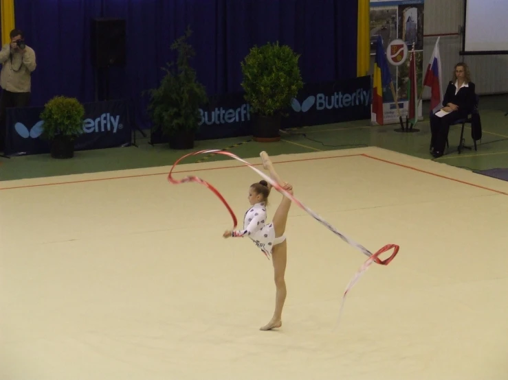  doing aerial acrobatic exercise in indoor arena