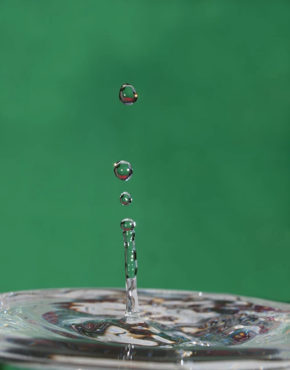 three droplets of water floating on top of a glass plate
