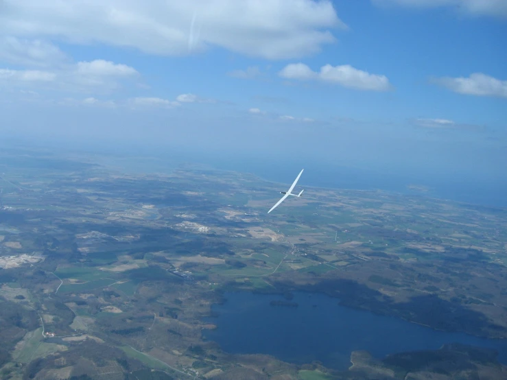 an airplane with wings out flying over land