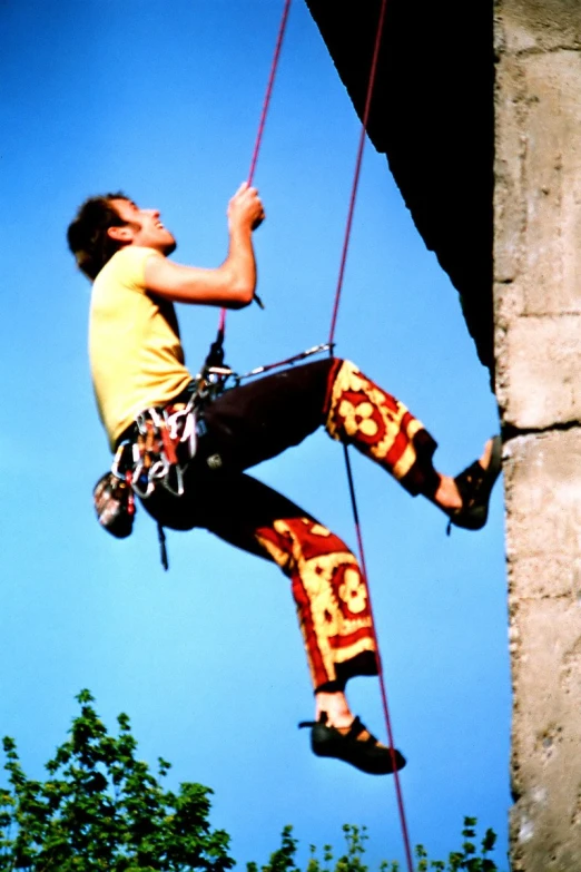 a man climbing up on a rock with his hands up