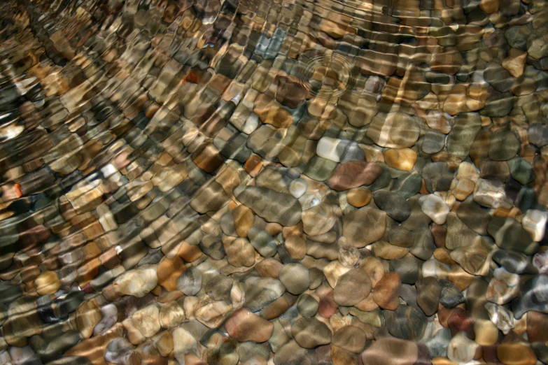 many rocks are in the water with their reflections