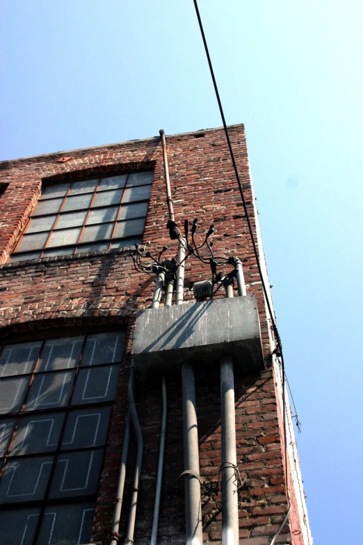 the side of an old brick building with electrical wires running from it