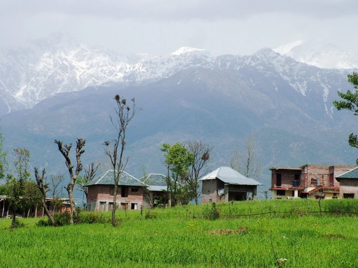 several houses on land next to a mountain