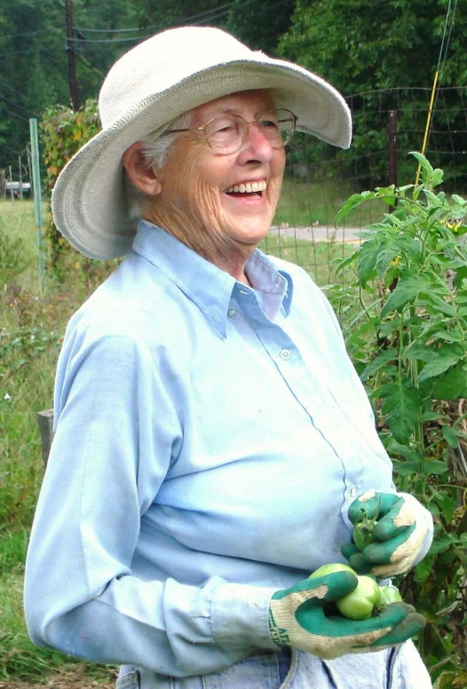 an older woman is holding some green fruit