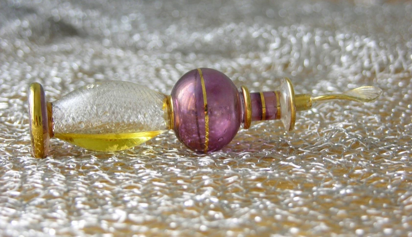 a colorful glass bottle on carpet with needle and thread