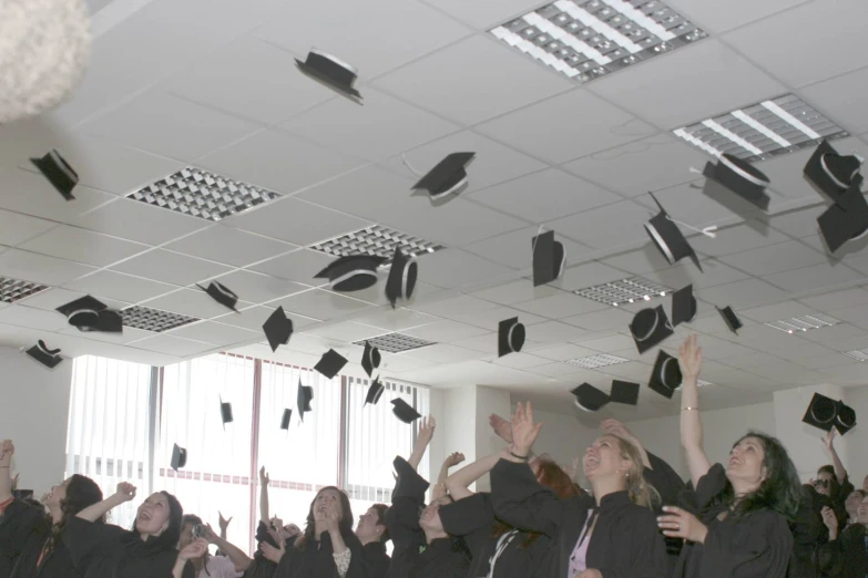 a group of people throwing hats in the air
