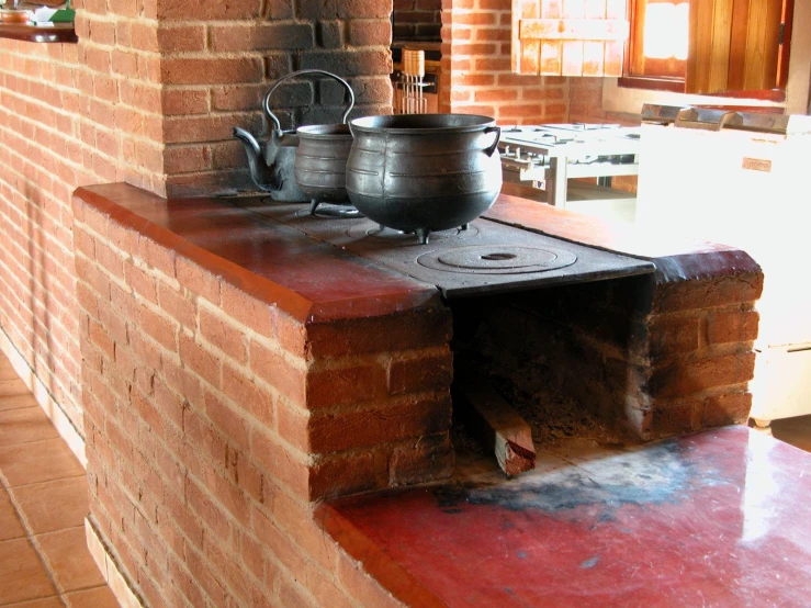 a kitchen has a brick stove with pot sitting on it