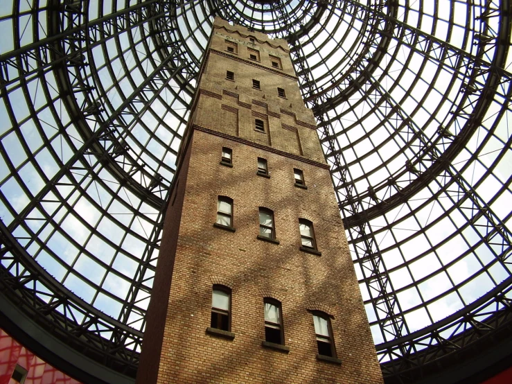 a clock tower looks up from under a metal roof