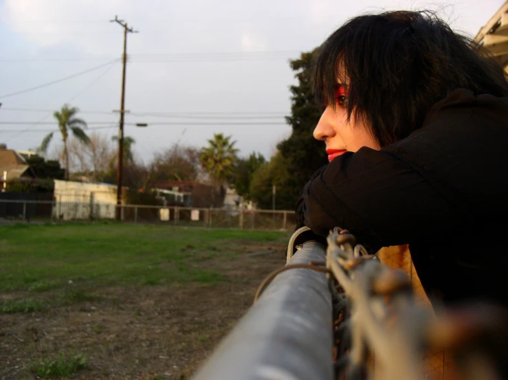 a girl is sitting on the railing in front of the house