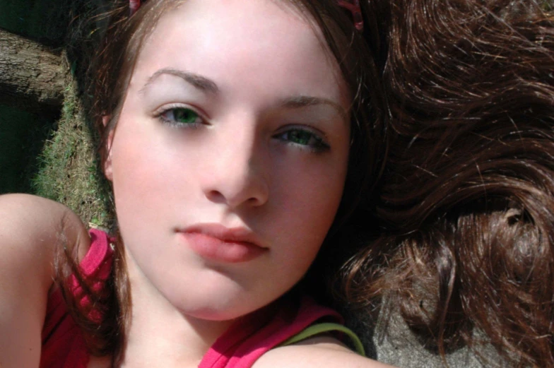 a woman laying on the ground next to a tree