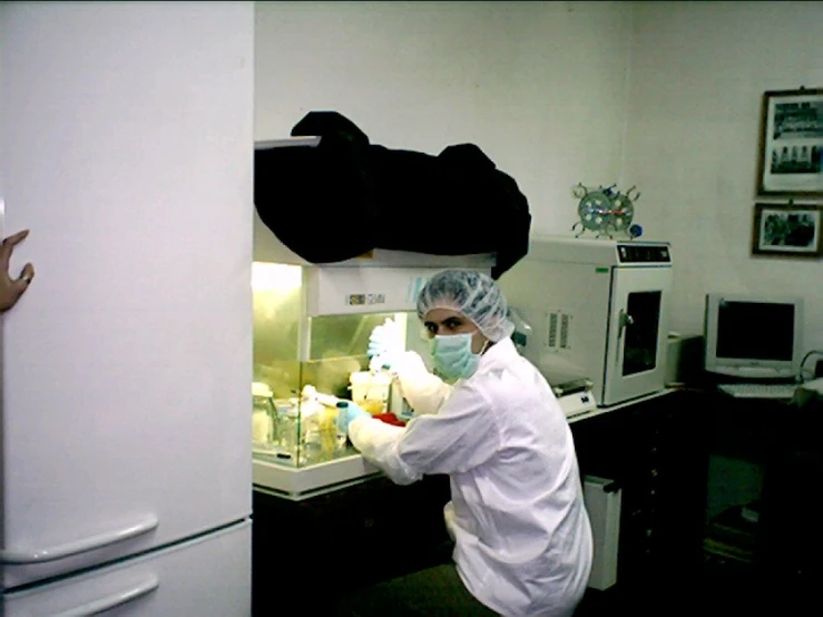 a person in a lab coat with gloves