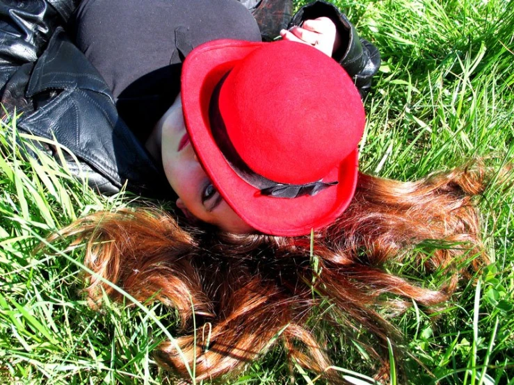 a woman in black is laying on the grass