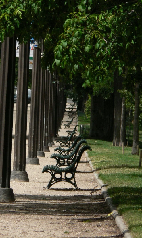 several park benches line up along a street