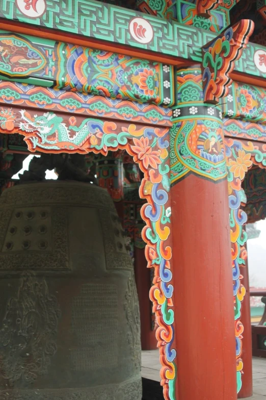 an elaborately designed bell tower under a large wooden tower