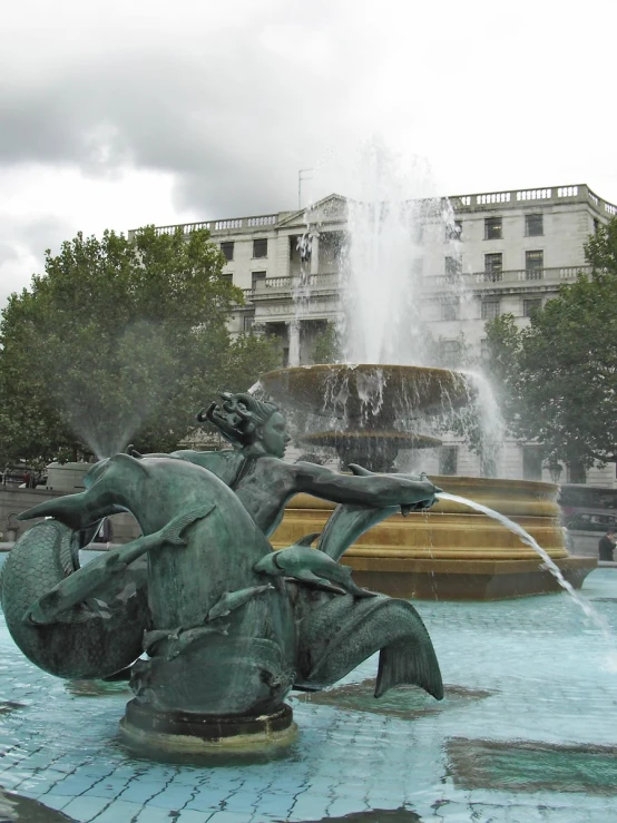 water fountain with large water spouting from the top and two mermaid figurines on top