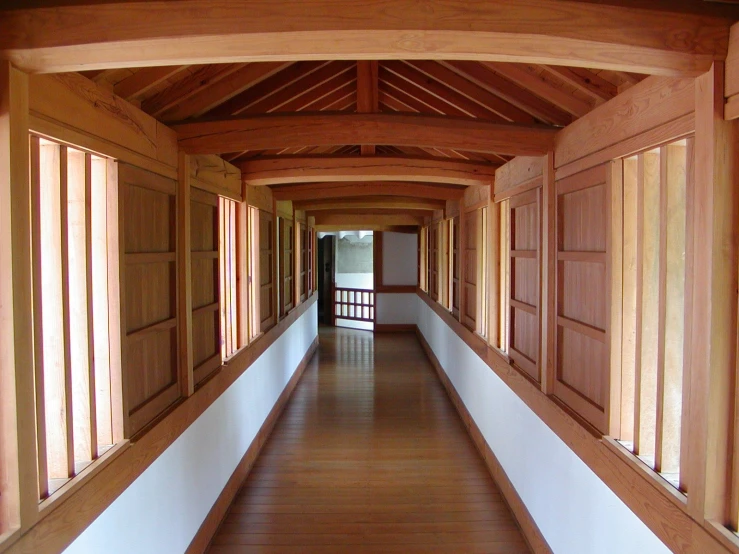 a long hallway with wooden columns and wood floors