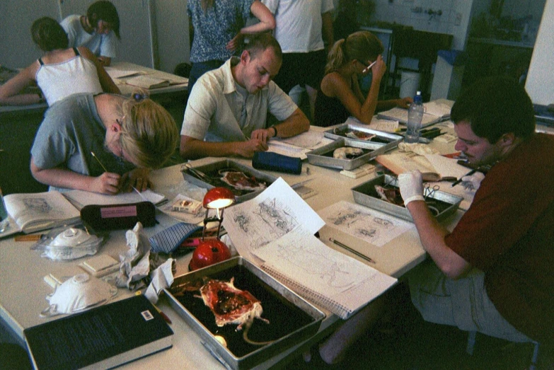 there are many people sitting at a table studying