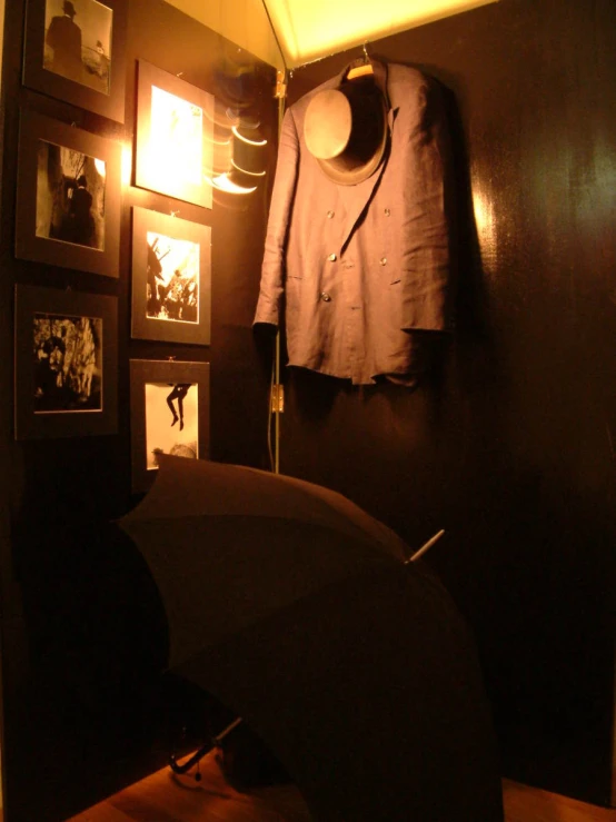 a lamp shines on a shelf and a coat and umbrella