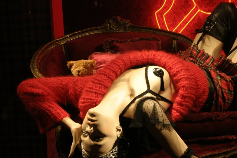 a woman laying on top of a red chair