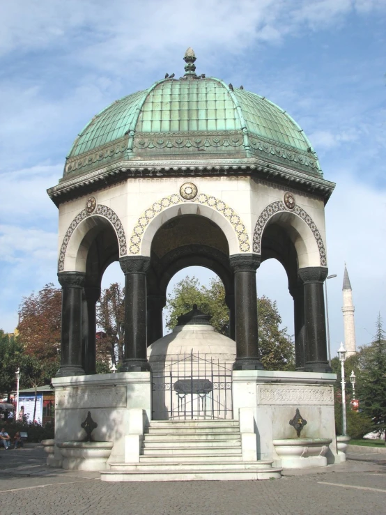 there is an old, stone gazebo with a green roof