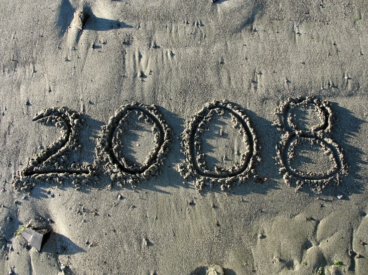 the word new year is written in sand with starfish