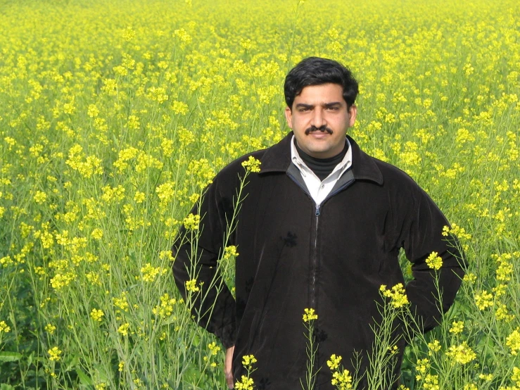 an old man standing in a field of flowers